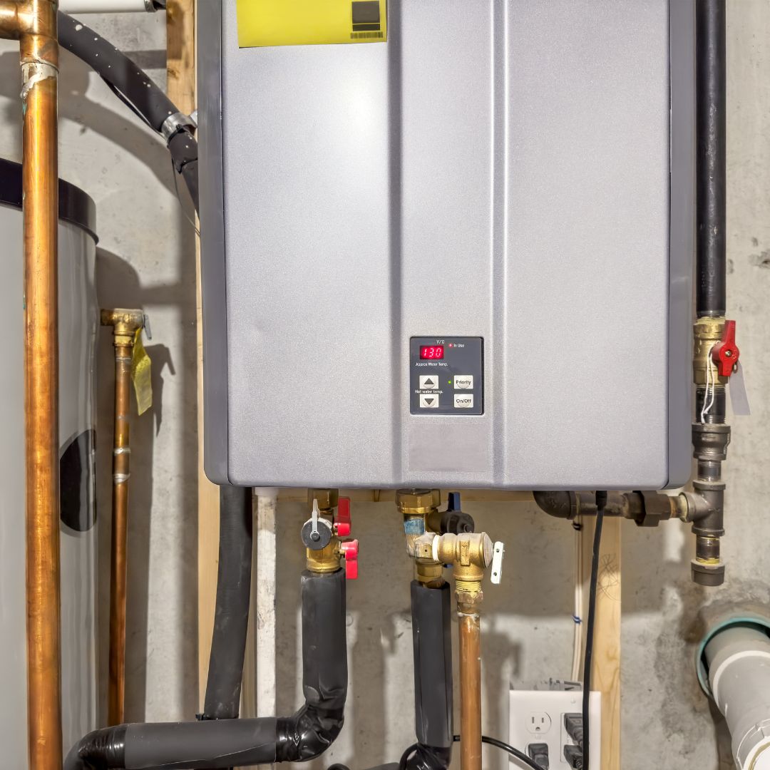 A tankless water heater, part of a recent heating installation, is mounted on a basement wall, with visible pipes and a digital temperature display showing 130 degrees.